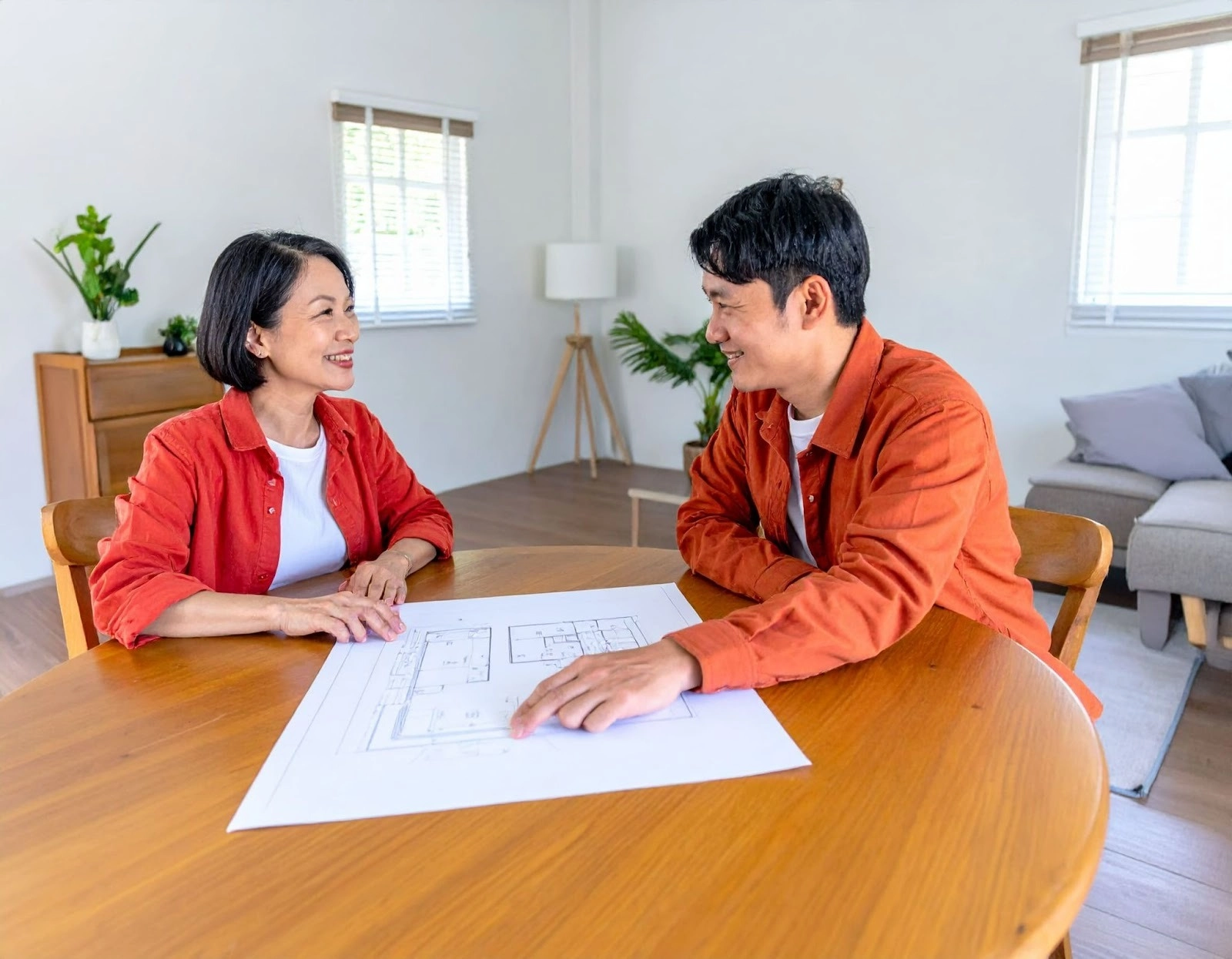 亞洲人室內設計師在客廳與中年夫妻討論養老宅空間規劃