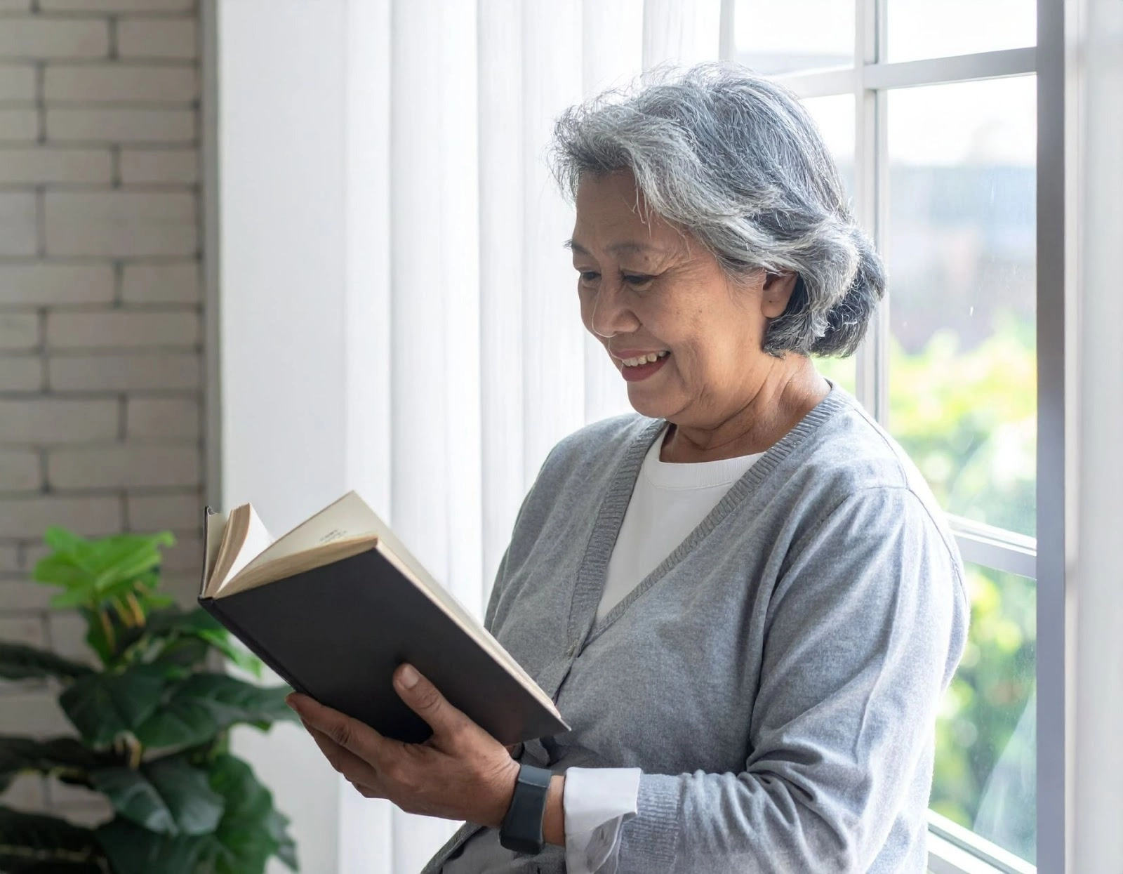 長者在客廳窗邊閱讀書本