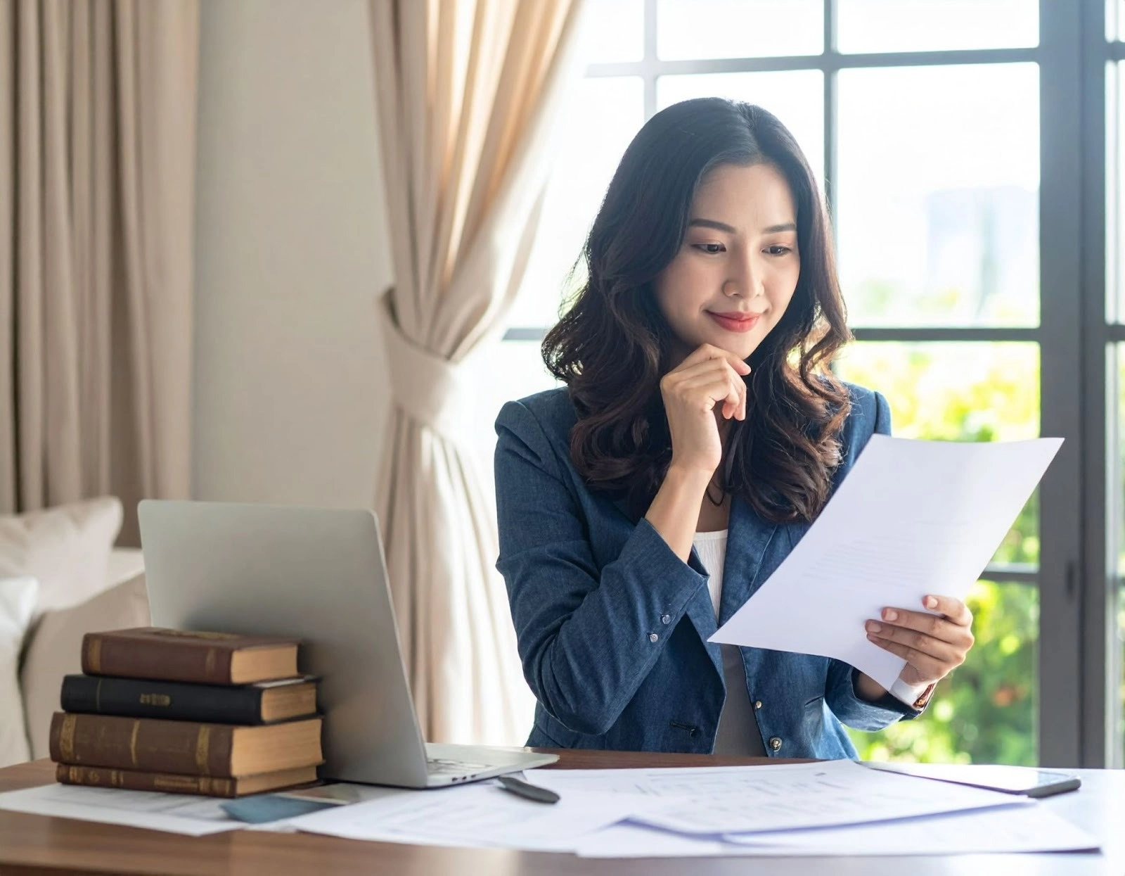 屋主在桌前查看裝潢合約文件露出思考表情