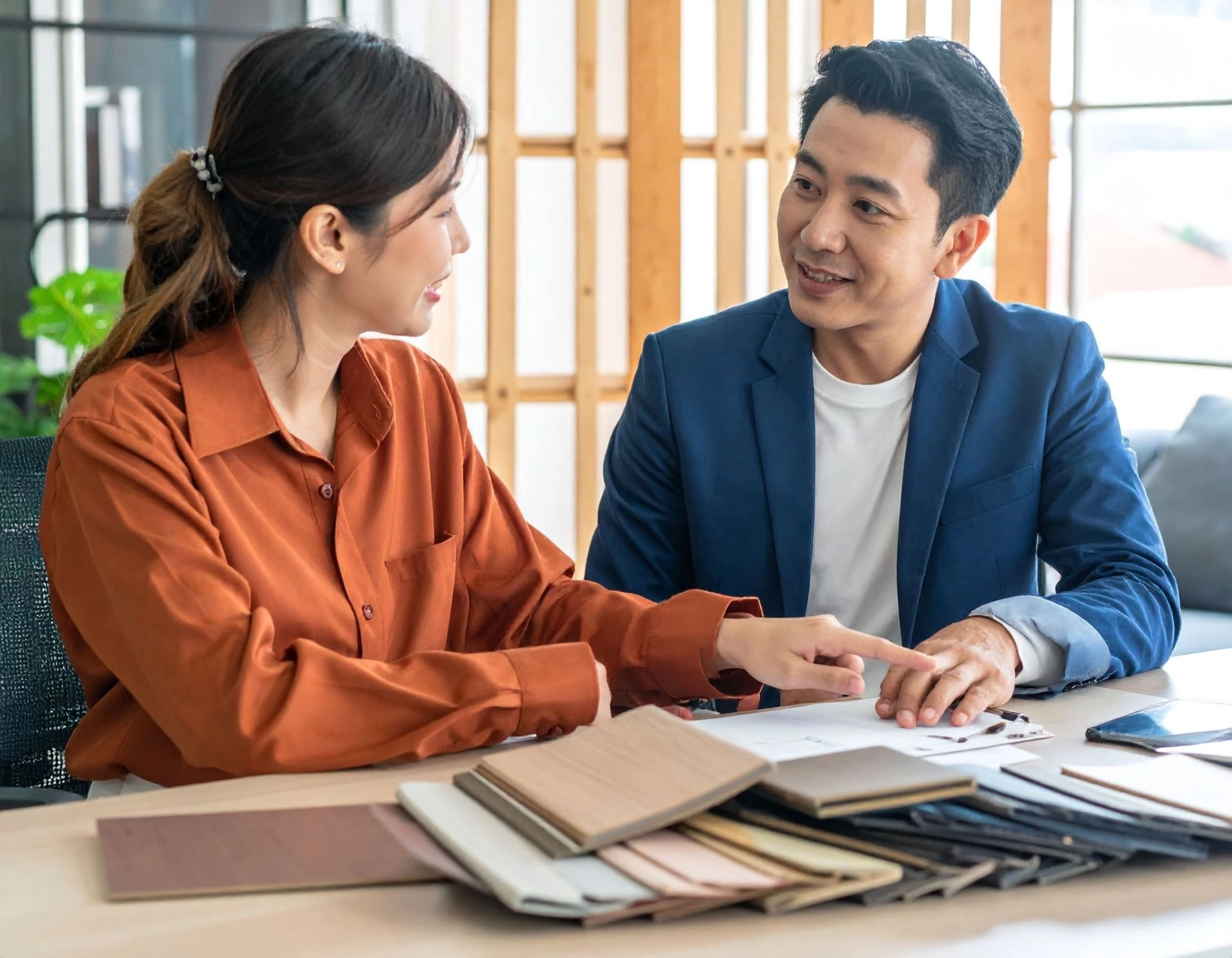 設計師（亞洲人）與屋主討論裝修選材